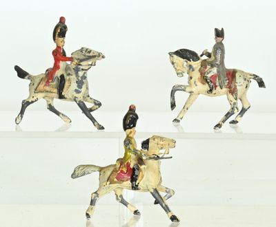 four figurines of people riding horses on a white surface