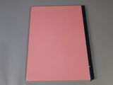 a pink notebook sitting on top of a white table