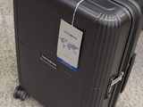 a black suitcase with a tag on it sitting on the floor