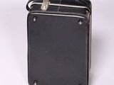 an old black suitcase sitting on top of a white surface