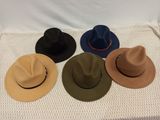six different hats are lined up on a white blanket