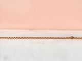 a close up of a gold chain on a marble surface