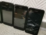 four cell phones are sitting next to each other on the floor