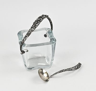 un récipient en verre contenant une cuillère et une autre cuillère à l'intérieur