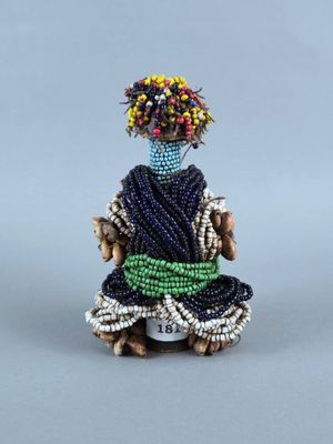 une image représentant une figurine de femme vêtue d'une robe bleue et portant des fleurs sur la tête