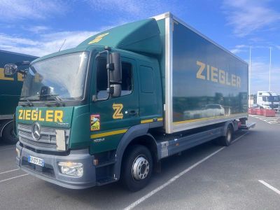 un camion vert garé sur un parking