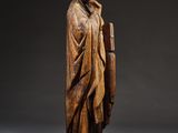 a wooden statue of a man with a book in his hand