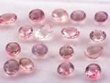 pink tourmaline gems are arranged on a white surface