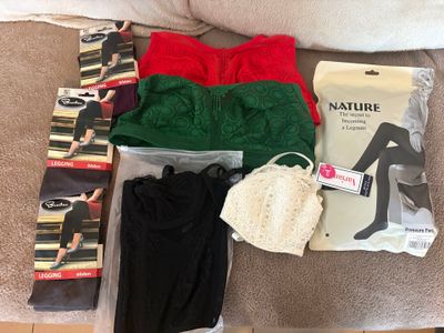 beaucoup de vêtements et un sac sur le canapé