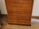 une armoire en bois sur laquelle est posé un sac bleu et vert