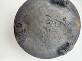 a metal object with writing on it on a white surface