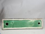 an image of a green plate with holes in it on a white surface