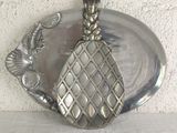 a silver plate with a silver cat on top of it