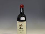 a bottle of wine sitting on a counter in front of a shelf