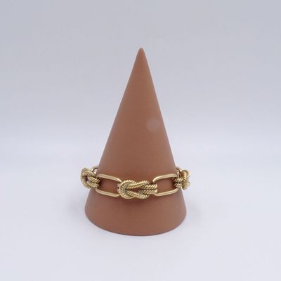 Gros plan sur une bague posée sur un cône, sur fond blanc