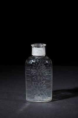 clear glass bottle on a black surface with a black background