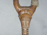 a wooden sculpture of a horned head on a stand