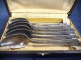 five spoons in a box with a gold handle