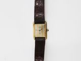 a brown leather watch with a gold buckle on a white background