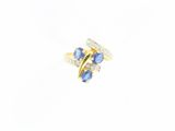 gros plan d'une bague en or avec des pierres bleues et blanches