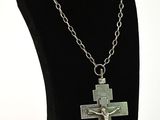 a close up of a necklace on a mannequin with a cross on it
