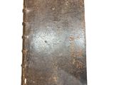 an old book that is sitting on a white surface