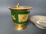 a green and gold cup and saucer on a table