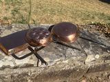des casseroles et des poêles sont posées sur un rebord en pierre à l'extérieur