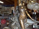 a statue of a woman holding a lamp in a shop
