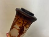 a woman holding a vase with a brown and white design on it