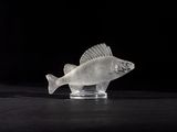 clear fish figurine sitting on a black surface with a black background