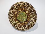 une assiette marron et verte posée sur une table blanche