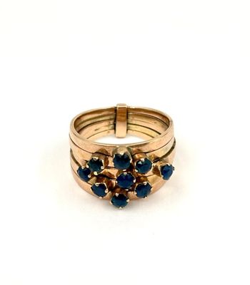 Gros plan sur une bague en or ornée de pierres bleues