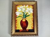 un tableau représentant des fleurs blanches dans un vase accroché au mur