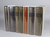 several books are lined up in a row on a white surface
