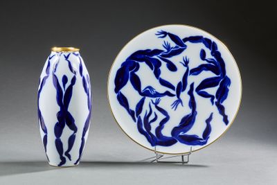 une assiette bleue et blanche et un vase bleu et blanc posé sur un socle