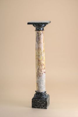 a close up of a tall marble column with a black top