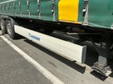 un semi-remorque vert et jaune garé sur un parking