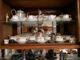 de nombreuses tasses et soucoupes sur les étagères de ce vaisselier
