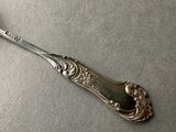 a silver spoon with a silver handle sitting on a table