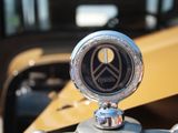un gros plan sur l'ornement du capot d'une voiture, sur lequel figure le symbole de la paix
