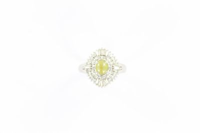 une bague en or blanc sertie d'une pierre jaune entourée de diamants
