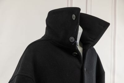 an image of a black coat hanging on a white wall