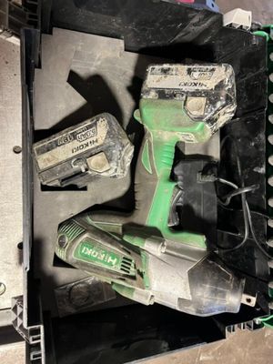 a green cordless drill and two other tools in a box