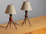 two lamps on top of a wooden dresser in front of a gray wall
