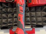 a red cordless drill in a case with other tools