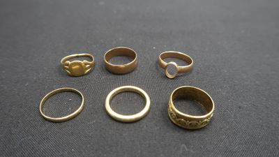 une pile de bagues en or posées sur une table