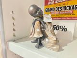 a figurine of a man sitting on a shelf