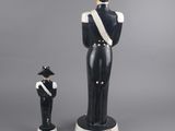 black and white figurine of a man in uniform and a woman in a hat