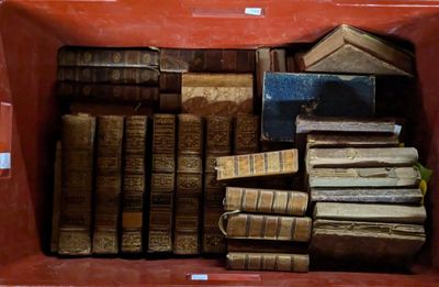 de nombreux livres anciens dans une boîte rouge posée sur la table